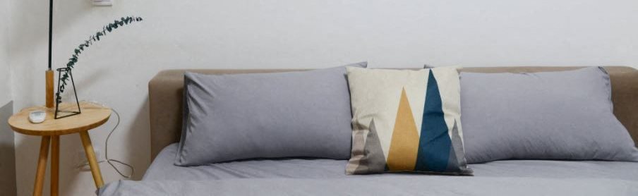Image of pillows and stand next to bed